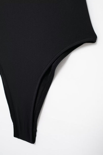 Traje de baño negro con escote desbocado y decoración metálica para mujer de verano