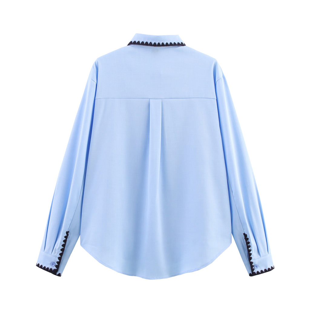 Chemise bleue à manches longues ample, style chic et automnal, inspirée par les coquillages.