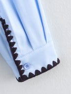 Chemise bleue à manches longues ample, style chic et automnal, inspirée par les coquillages.