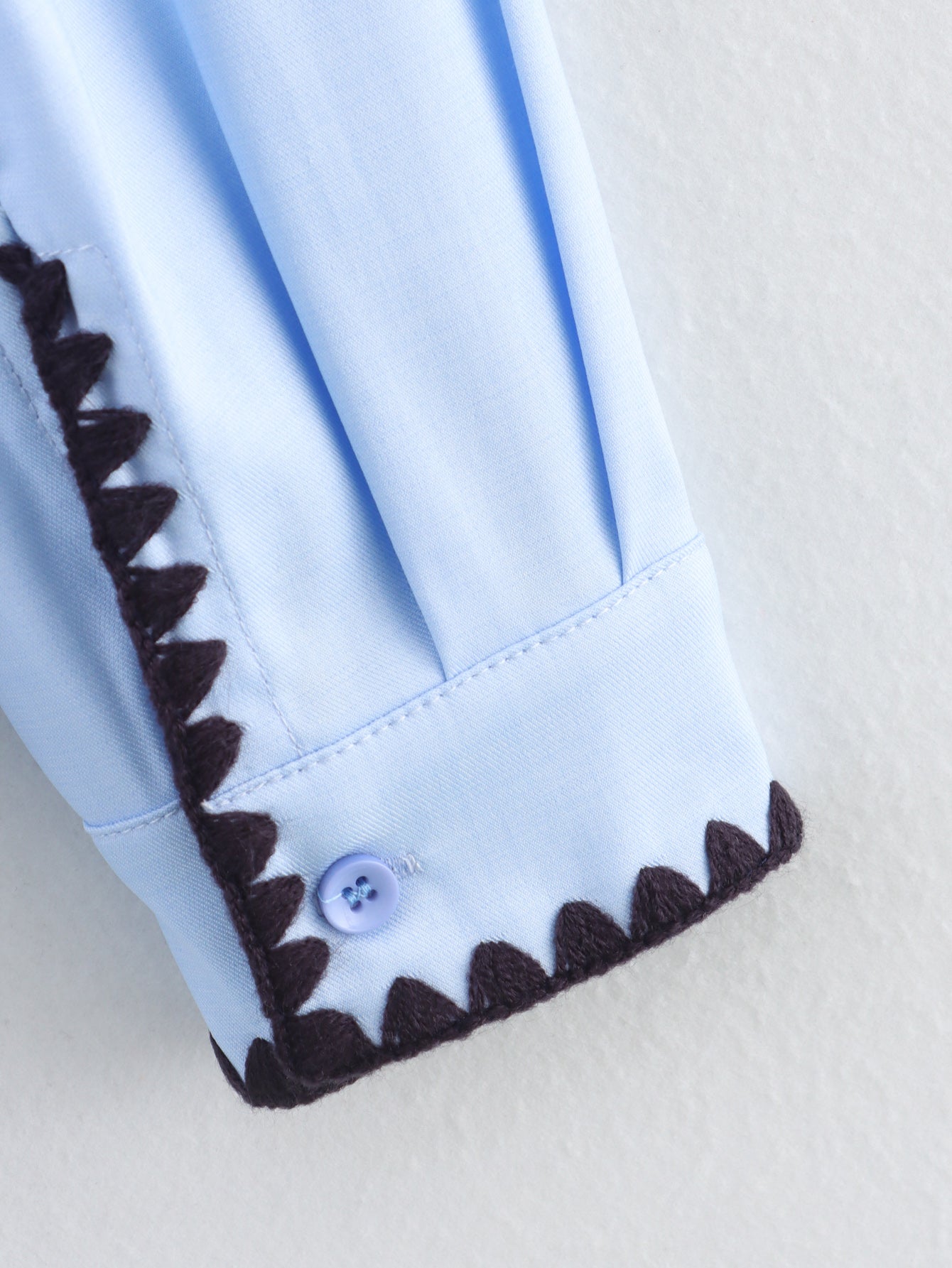 Chemise bleue à manches longues ample, style chic et automnal, inspirée par les coquillages.