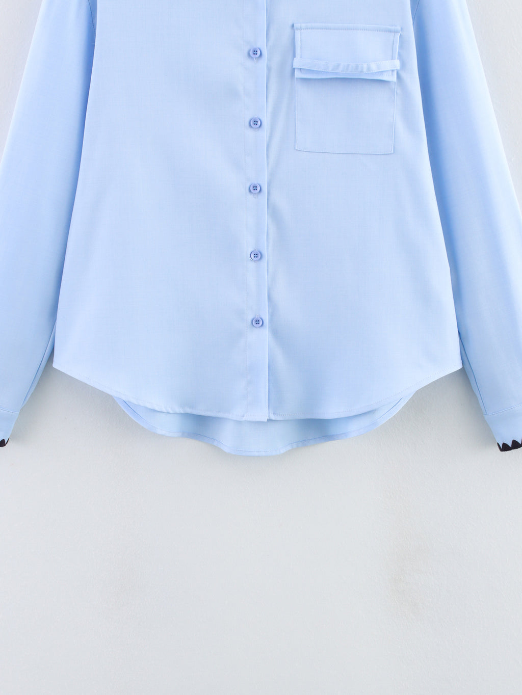 Chemise bleue à manches longues ample, style chic et automnal, inspirée par les coquillages.