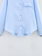 Chemise bleue à manches longues ample, style chic et automnal, inspirée par les coquillages.