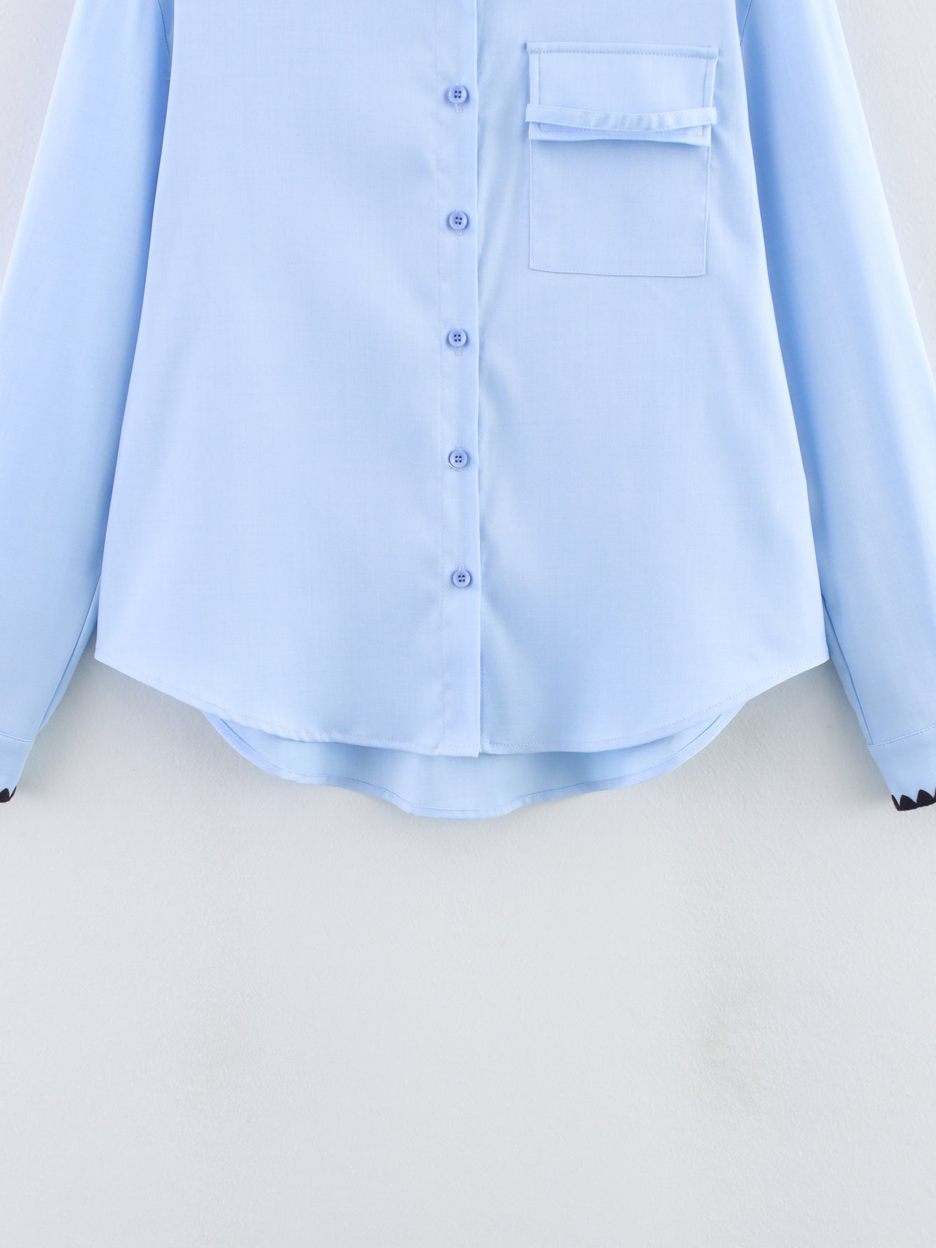 Chemise bleue à manches longues ample, style chic et automnal, inspirée par les coquillages.