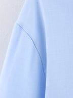 Chemise bleue à manches longues ample, style chic et automnal, inspirée par les coquillages.