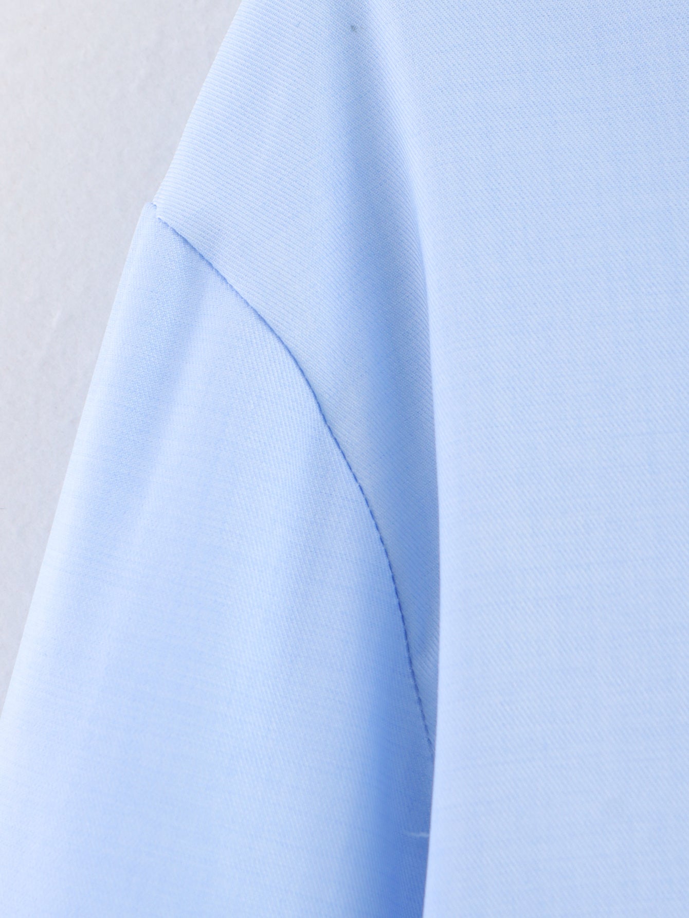 Chemise bleue à manches longues ample, style chic et automnal, inspirée par les coquillages.