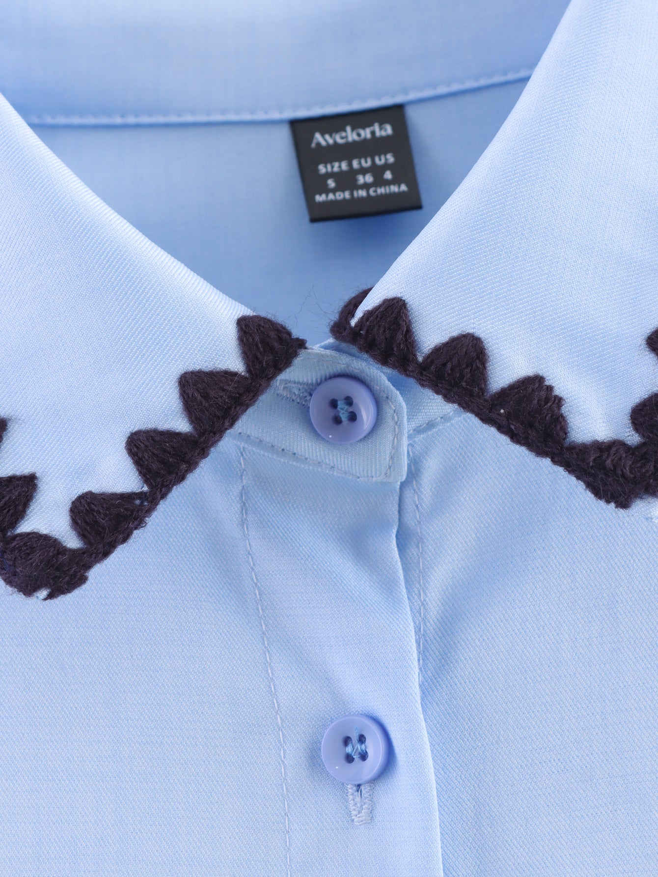 Chemise bleue à manches longues ample, style chic et automnal, inspirée par les coquillages.