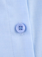 Chemise bleue à manches longues ample, style chic et automnal, inspirée par les coquillages.