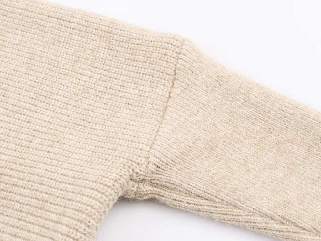 Pull asymétrique à col roulé et manches longues pour femme, style hiver, avec surpiqûres duveteuses et coupe ample.