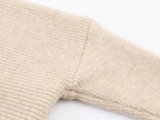 Pull asymétrique à col roulé et manches longues pour femme, style hiver, avec surpiqûres duveteuses et coupe ample.