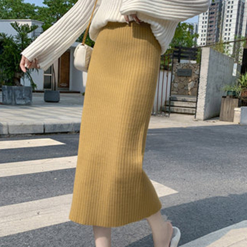 Jupe tricotée femme automne-hiver avec pull, taille haute, mi-longue, en laine épaisse fendue sur les hanches.