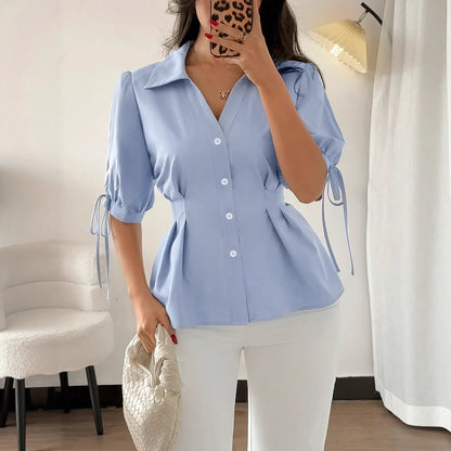 Chemise cintrée à la taille, manches courtes, poignets lacés, plissée et ajustée, idéale pour le printemps et l'été. Femme professionnelle.