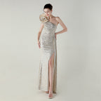 Robe de soirée asymétrique à col diagonal et queue de poisson, ornée de fleurs et de perles artisanales. Idéale pour un dîner, un mariage, une remise de prix ou une cérémonie.